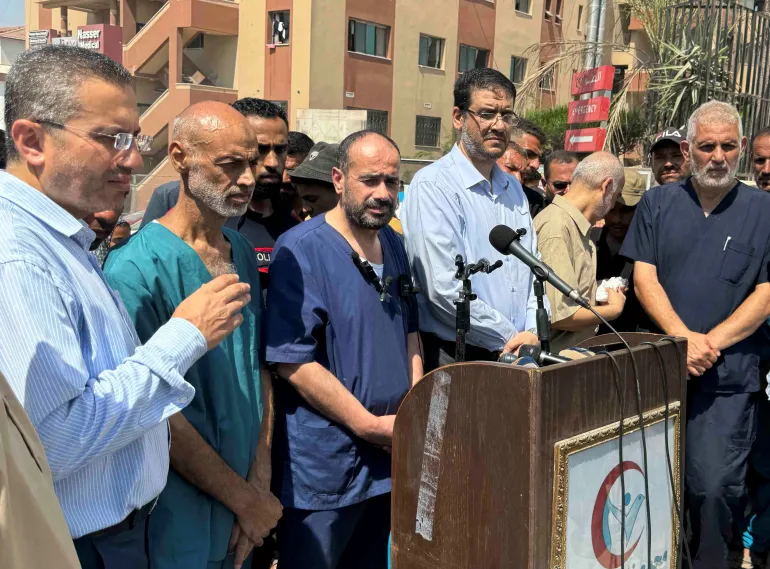 Dr Mohammad Abu Salmiya, ketiga dari kanan, berbicara kepada media pada hari Senin [Mohammed Salem/Reuters]