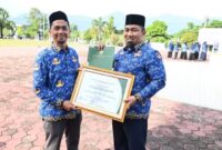 Pj Bupati Aceh Besar Muhammad Iswanto SSTP MM menerima Penghargaan dari Kemendes RI atas kepedulian terhadap Pengembangan Teknologi Tepat Guna yang diserahkan Kadis DPMG Aceh Besar Carbaini SAg di halaman Kantor Bupati Kota Jantho, Aceh Besar, Selasa 23 juli 2024/(Mercinews/Pemerintah Aceh)