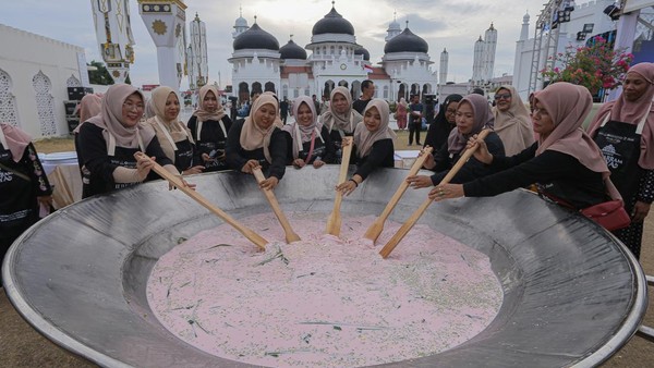 Sejumlah warga Banda Aceh mengaduk bubur asyura saat pencatatan rekor Museum Rekor Dunia Indonesia (MURI) belanga terbesar dalam Sambot Muharram Raya di Masjid Raya Baiturrahman, Banda Aceh, Aceh, Sabtu (13/7/2024).