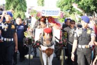 Kepala Kantor Imigrasi Ponorogo, Happy Dipayuda, bersama Ketua Dharma Wanita Persatuan (DWP) Kantor Imigrasi Ponorogo, Dini Happy Dipayuda, nai kereta kuda dalam rangkaian Grebeg Suro 2025 melalui keikutsertaan dalam Kirab Pusaka, Pawai Lintas Budaya, dan Jamasan Pusaka yang digelar pada Kamis (26/6/2025).(Foto:Humas Kanim Ponorogo)
