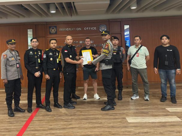 Petugas Imigrasi Ngurah Rai mengamankan seorang buronan interpol asal Inggris berinisial SL (45) di Bandara Internasional I Gusti Ngurah Rai Bali.(Foto: Dok. Kanim Ngurah Rai)