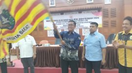 Agus Ramdani mengibarkan pataka usai ditetapkan sebagai Ketua KONI Jakarta Barat periode 2026-2030 dalam Musorkot di Ruang Ali Sadikin, Kantor Wali Kota Jakarta Barat, Senin (27/4/2026). (Foto: istimewa)