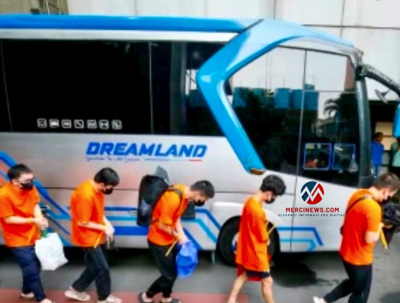Para WNA terduga pelaku sindikat judol jaringan internasional berjalan menuju bus untuk dipindahkan ke imigrasi setelah berhasil ditangkap di Hayam Wuruk Plaza Tower, Jakarta Barat, Minggu (10/5/2026). (Foto: Fir/Mercinews.com)