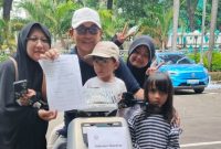 Rindu Alya Dewina Mariam bersama keluarga usai menerima hadiah doorprize utama berupa sepeda motor listrik pada kegiatan Fun Walk World Press Freedom Day yang digelar Dewan Pers di Jakarta, Minggu (10/5/2026). Rindu merupakan putri dari Pengurus Serikat Media Siber Indonesia Pusat, Iwan Jamaluddin. (Foto: Dok. SMSI Pusat)