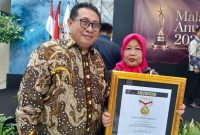 Ketua Umum SMSI Pusat, Firdaus (kiri) bersama Pemred Media Sudut Pandang Umi Sjarifah saat acara Malam Anugerah SMSI di Hall Dewan Pers, Jakarta, Kamis (18/6/2026) malam. (Foto: istimewa)