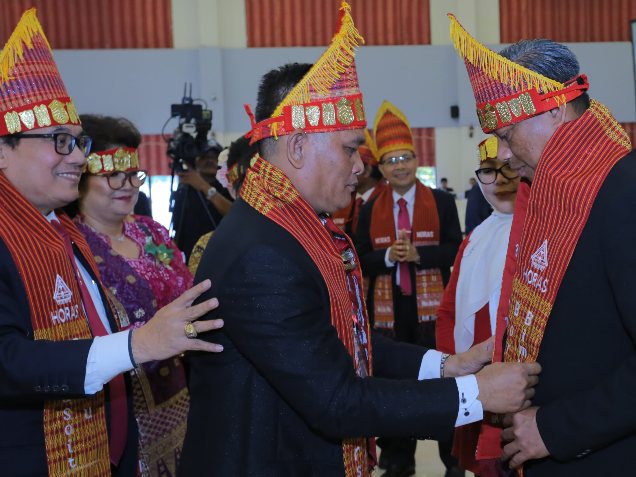 Keluarga Besar Hutasoit menyematkan ulos dan sortali kepada Wali Kota Jaktim Munjirin, didampingi Ketua Tim Penggerak PKK Jaktim Essie Feransie Munjirin, saat menghadiri Pesta Partangiangan 2026 Borsak Bimbinan Hutasoit dan Boru se-Jabodetabek di Jakarta Timur, Minggu (7/6/2026). Penyematan tersebut menjadi simbol penghormatan, persaudaraan dan pelestarian nilai-nilai budaya Batak.(Foto: Dok. Pemkot Jaktim)