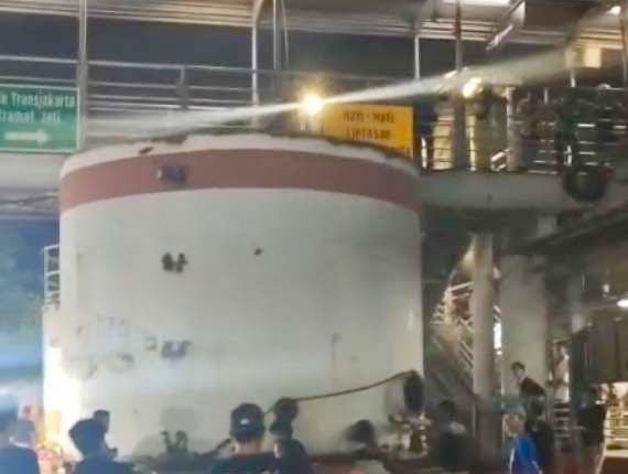 Truk trailer yang mengangkut tangki tersangkut di JPO depan Pasar Kramat Jati, Jalan Raya Bogor, Jakarta Timur, Minggu (16/8/2026) dini hari. (Foto: istimewa)