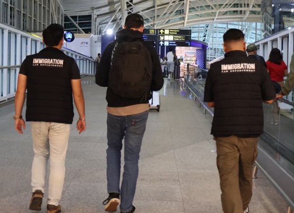 Petugas Kantor Imigrasi Ngurah Rai mengawal proses deportasi WNA asal Australia berinisial B.A di Bandara Internasional I Gusti Ngurah Rai, Bali, Selasa, 8 September 2026. (Foto: Dok. Kanim Ngurah Rai) 